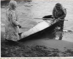 Eskimo exiting kayak on shore Image
