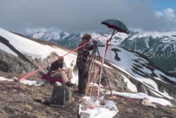 Gary Frederick, recording, and Lieutenant Ginny Newell, observing, across the valley from Redoubt Volcano. Image