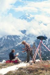 Gary Frederick, recording, and Lieutenant Ginny Newell, observing, across the valley from Redoubt Volcano. Image