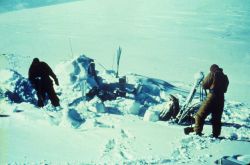 Digging out snow to find the mark for observing an astro station in winter. Image