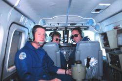 Photographer Sean Linehan in foreground with pilots Lieutenant Mark Hickey and Lieutenant Commander Greg Lamontagne on Rockwell Turbo Commander N53RF. Image