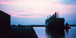 A large break-bulk merchant vessel docking at sunset at Lake Charles. Image