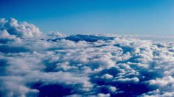 Maui peaking through the clouds as seen from aircraft. Image