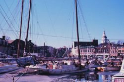 Sailing oyster dredger and statehouse on a cold morning in Annapolis. Image