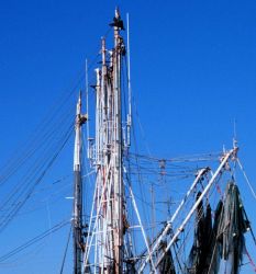 Masts and booms of shrimp boat with nets drying. Photo