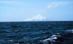 An Aleutian Island peak looms in the distance. Image