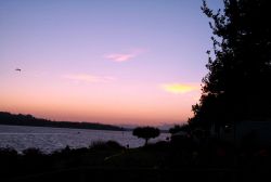 Fox Island and a silhouette of the Olympic Range as seen from Gig Harbor at sunset. Image