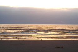 Sun setting behind an offshore fog bank at Seaside. Image