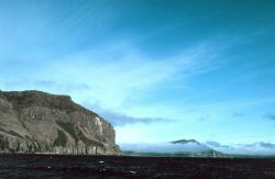 Majestic cliffs rise out of the sea at Puale Bay, called the windiest spot on the Alaskan coast. Image