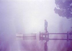Fisherman checking his boat on a foggy morning. Image