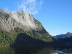 Mist-draped cliffs in the Rudyerd Bay. Image