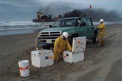 Setting up equipment to sample oil spill near grounded vessel. Image