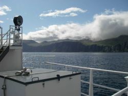 Clouds pouring over an Aleutian island. Image