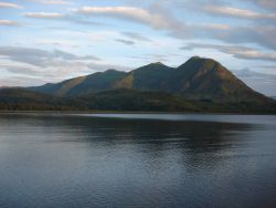 Mountains rise above a quiet Kodiak Island cove at the end of the day. Image