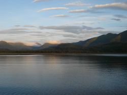 Mountains rise above a quiet Kodiak Island cove at the end of the day. Image