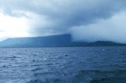 Cloud shrouded mountains seen from at sea. Image