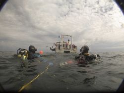 Divers Benjamin Cowie-Haskell and Deborah Marx wait to be picked by the R/V Auk after a dive to the shipwreck of the coal schooner Paul Palmer Image