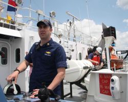 Lieutenant Commander Ben Evans operates propulsion controls on the port bridge wind of the NOAA Ship FERDINAND R Image