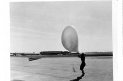 Launching a pilot balloon during strong winds at St Image