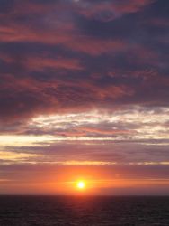 Sun setting over the ocean. Image