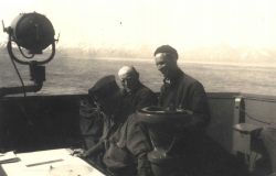 Commander William Malnate at navigator's table with Boatswain Peterson in center and Lt Image