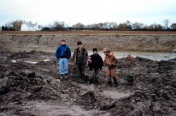 Local children stand in the low marsh area adjacent to the pre-restored ditch of a headwater stream. Image