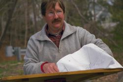 A surveyor reads the chart that tells him exactly where the historical dam that is scheduled for removal is located. Image