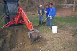 Breaking ground at the dam removal site to test soil for contaminants. Image