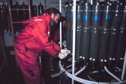 Drawing a water sample from Conductivity-Temperature-Depth (CTD) rosette water sample bottles. Image