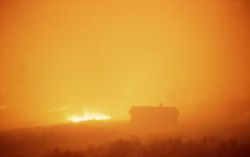 Wind driven sage (ground) fire approaching Blacktail cabin at night Image