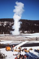 Looking down at snow machines, people & Old Faithful erupting in the winter Image